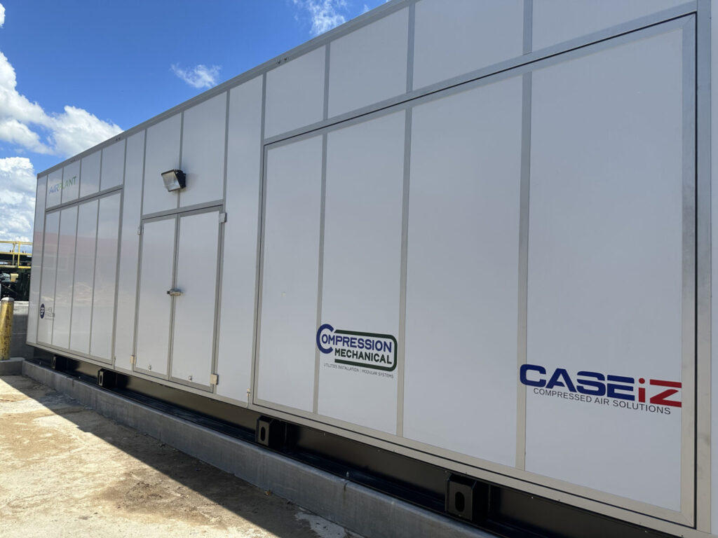 Large white industrial air compressor unit with logos for Compression Mechanical and CASEiZ Compressed Air Solutions.